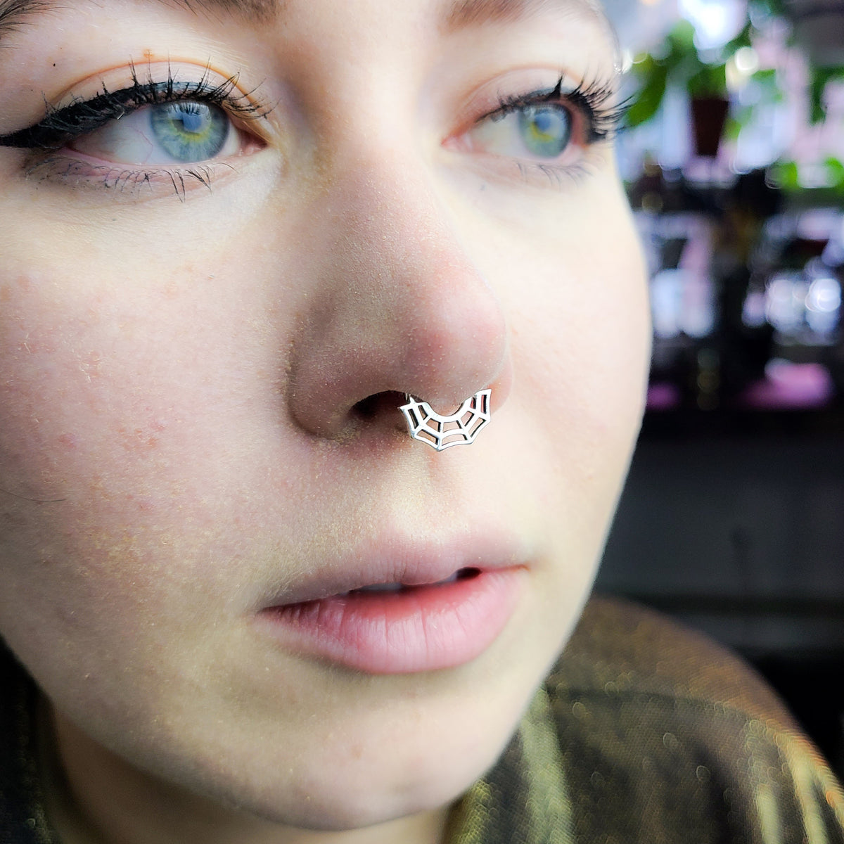 Person wearing a concealed septum retainer